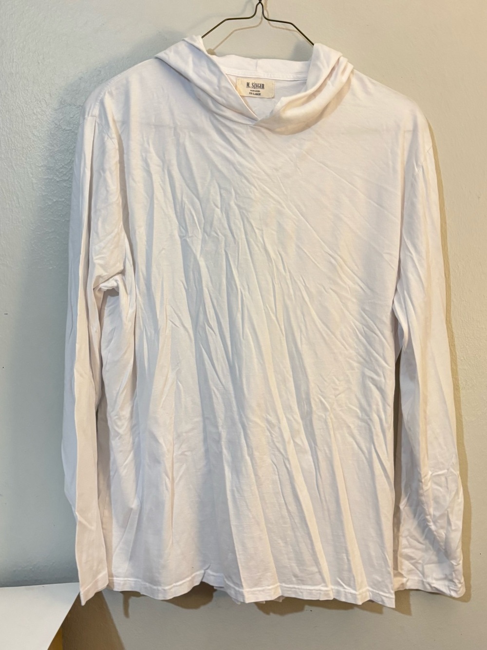 M. Singer white long-sleeve hooded t-shirt or lightweight hoodie.